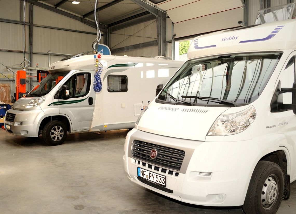 Zwei Wohnmobile in Werkstatthalle